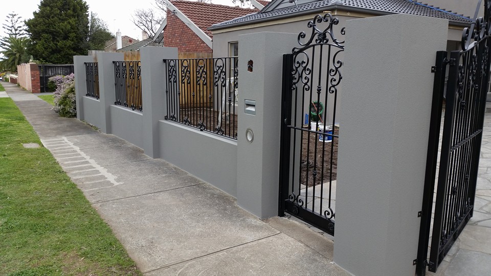 Close view of rendered front fence pillars with a textured grey finish in Essendon